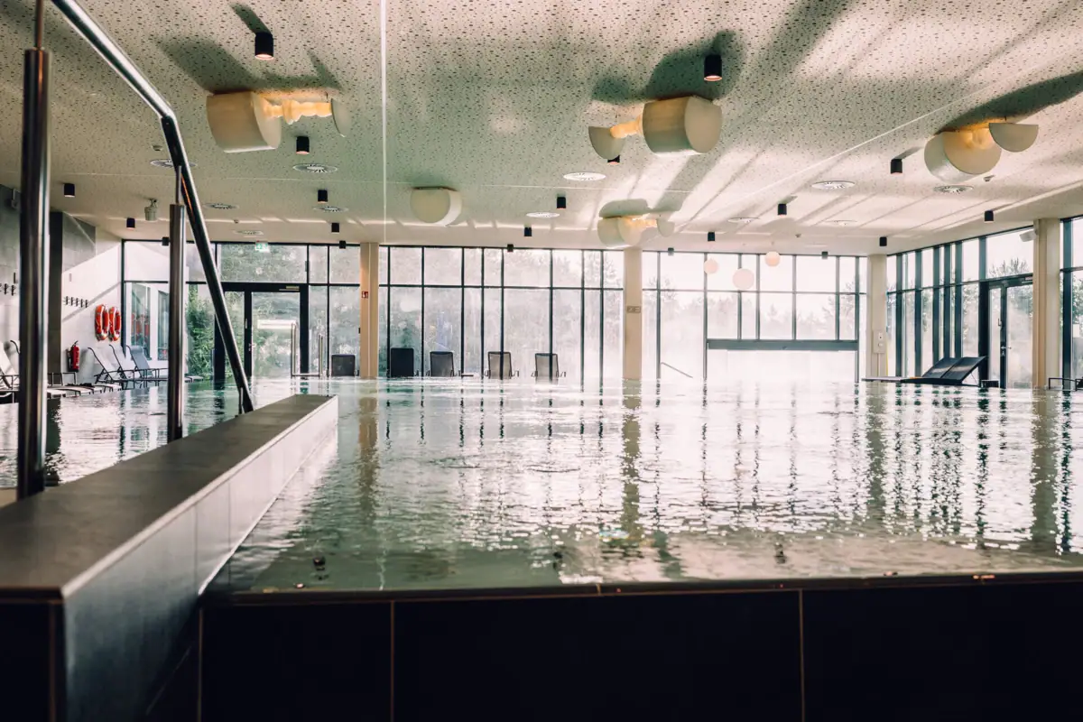 Day SPA im aja Bad Saarow Großes Hallenbad mit großen Wänden und Fenstern.