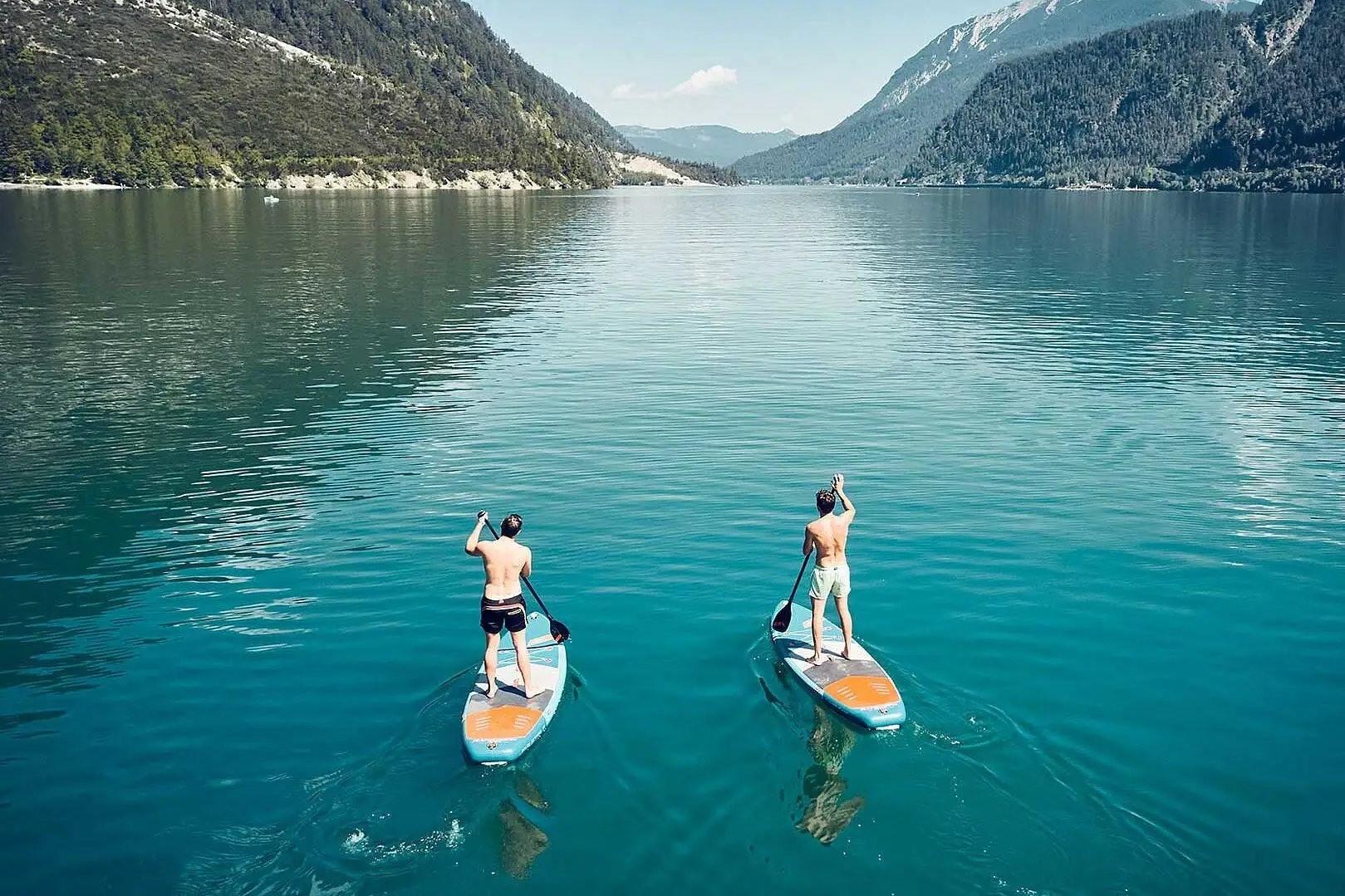 Stand-up-Paddling Zwei Männer auf Paddleboards auf einem See.