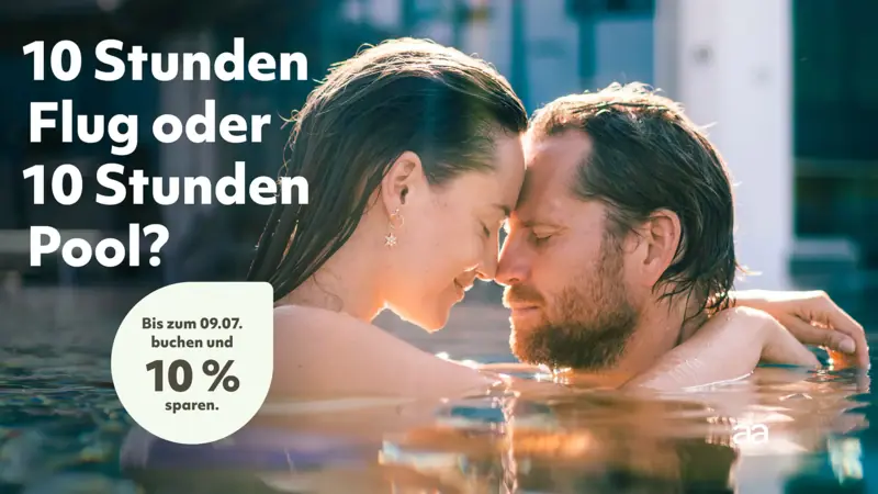 Ein Mann und eine Frau küssen sich im Wasser.