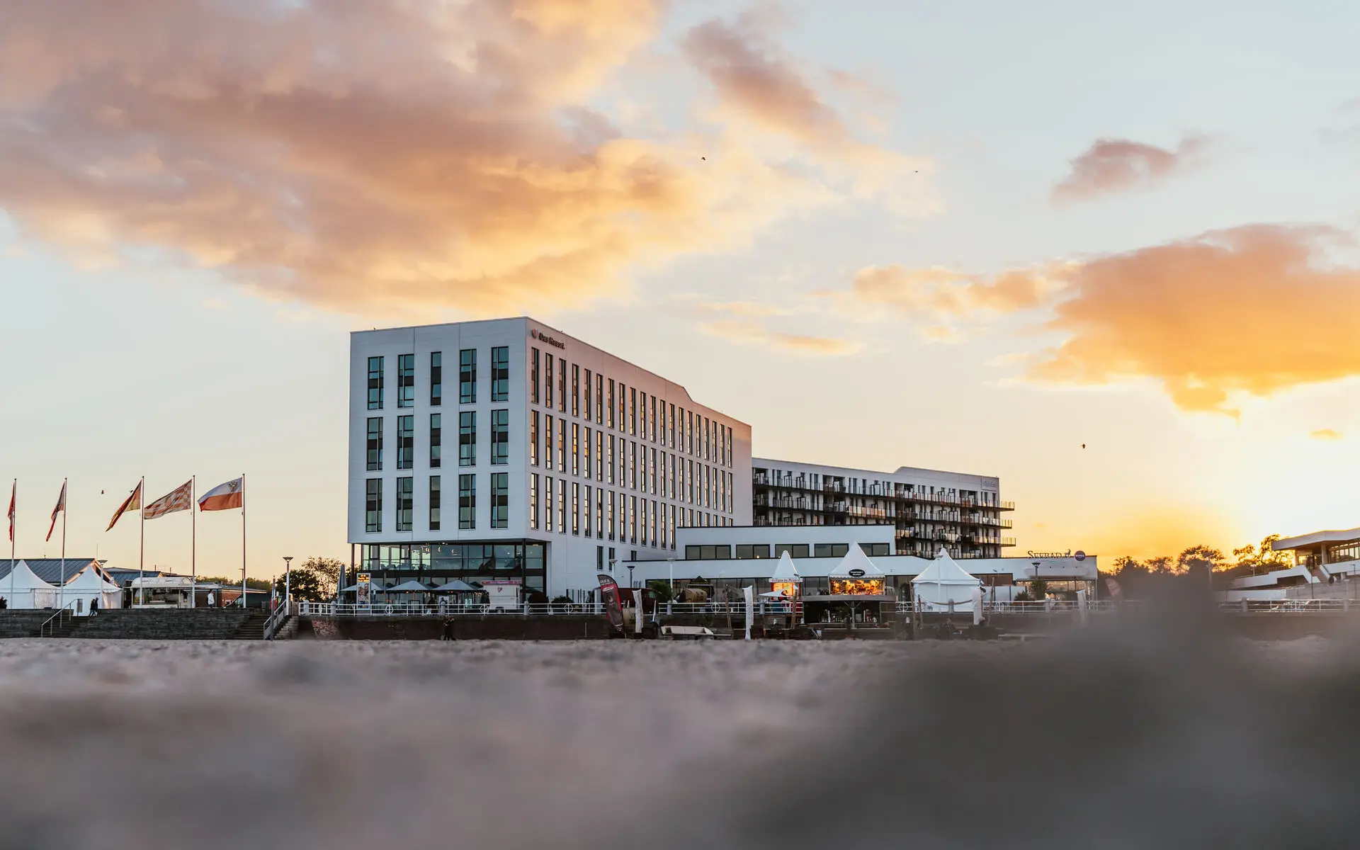 Ein Gebäude mit Flaggen davor bei Sonnenaufgang.