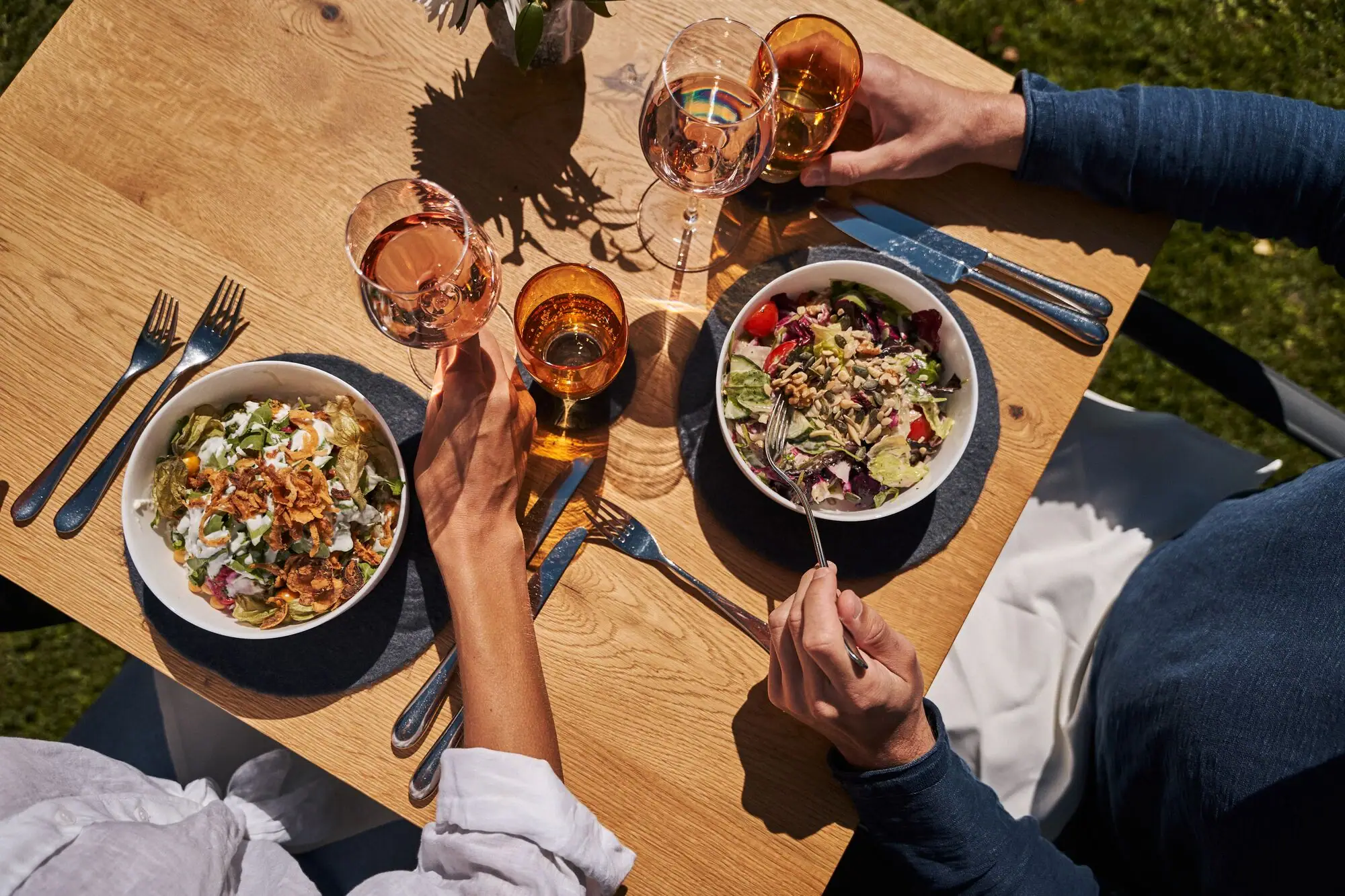 Gastgarten Eine Gruppe von Menschen isst an einem Tisch mit Essen und Getränken.