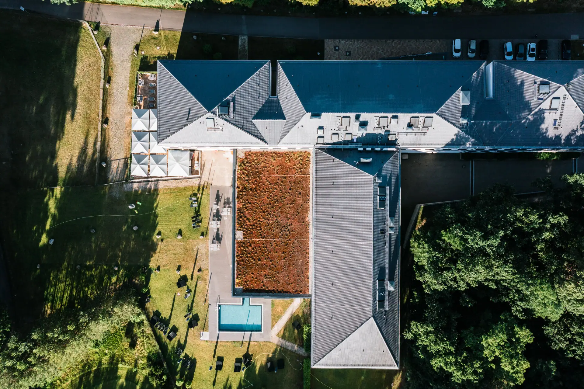 Ein Gebäude mit Pool und Rasen von oben fotografiert.