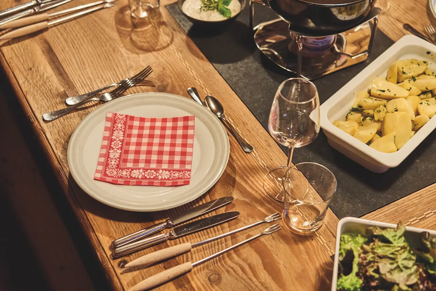 A table laid with food, crockery and cutlery.