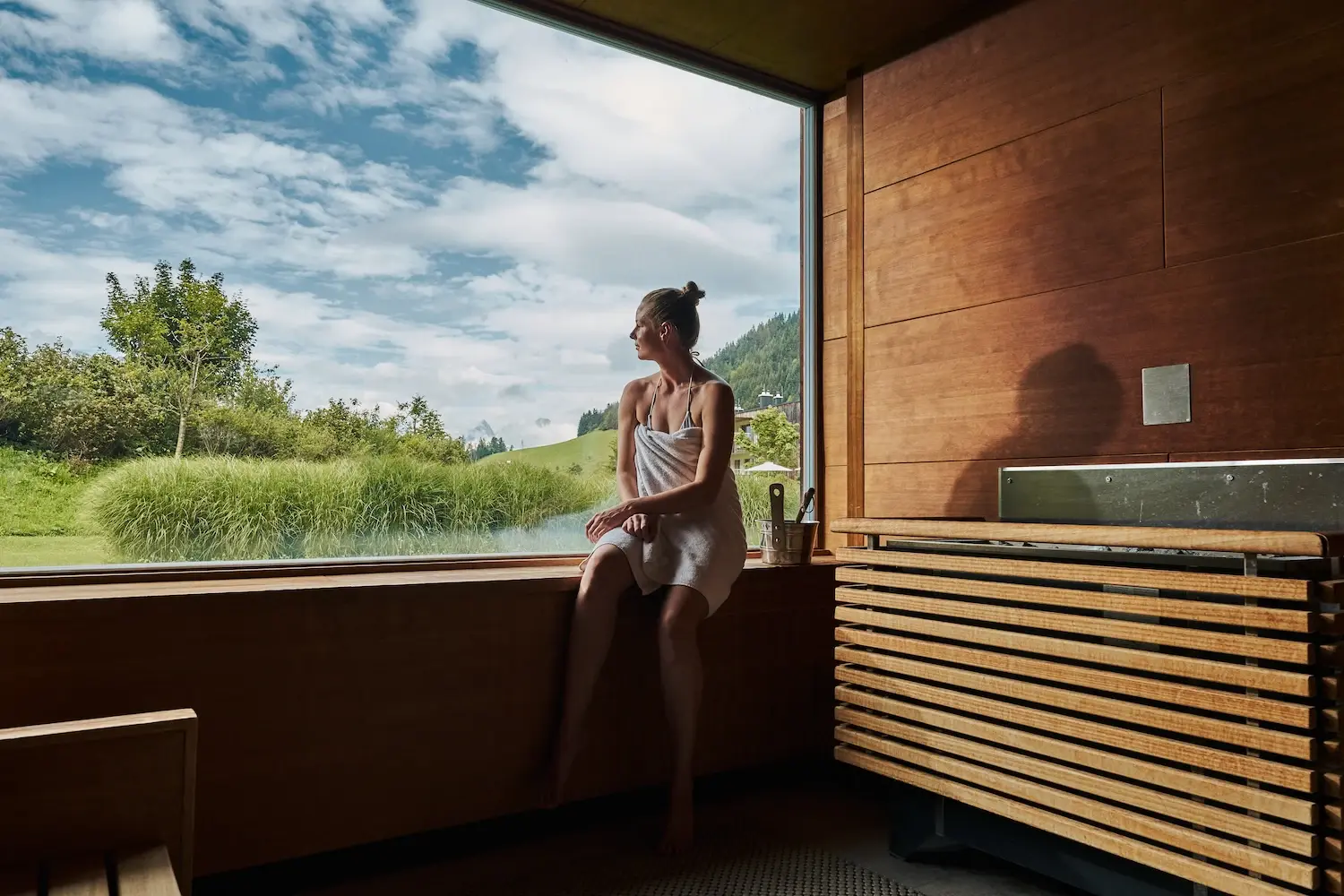 Sauna Eine Frau sitzt auf einer Fensterbank und schaut aus dem Fenster.