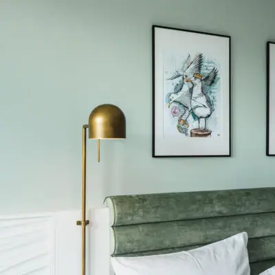 Neue Zimmer im aja Warnemünde Lampe neben einem Bett im Innenraum.