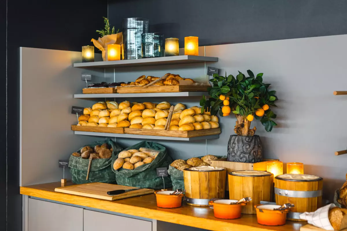 Frühstück im JEDERMANNS Ein Buffet mit Brot und Orangen darauf.
