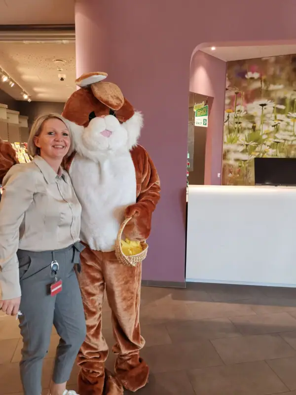 Eine Frau steht neben einer Person in einem Kleidungsstück.