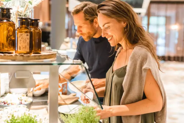 Ein Mann und eine Frau stehen vor einer Buffetstation.