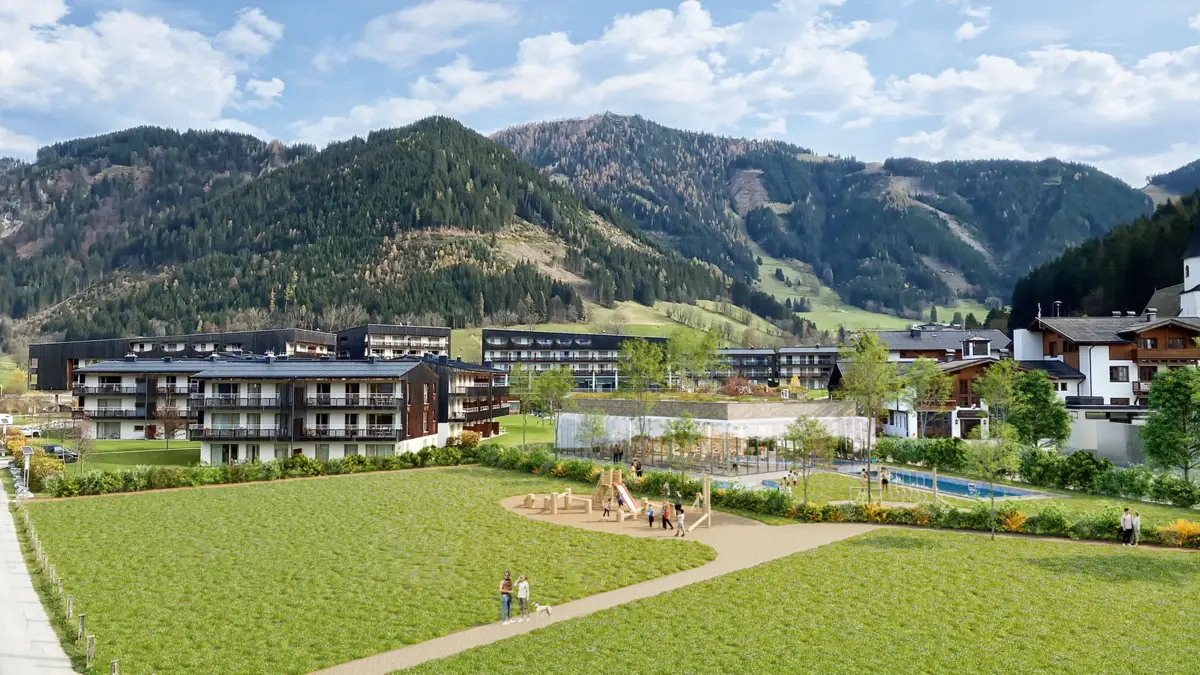 Badehaus Werfenweng  Der Hotelkomplex mit dem neuen Badehaus von außen im Sommer mit dem Außenpool und spielenden Kindern auf einem Spielplatz.