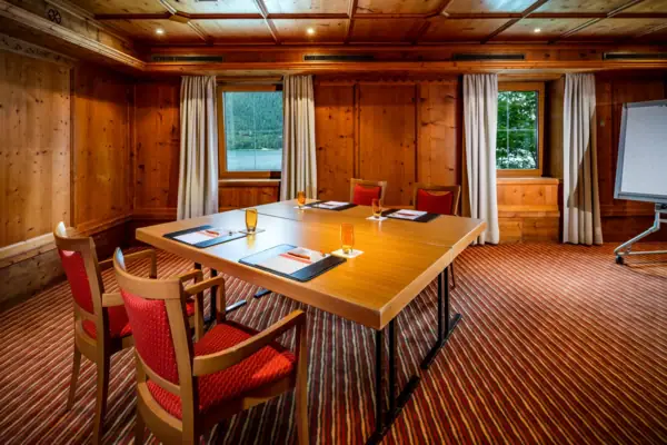 Tagungsraum mit einem Tischblock und vier Stühlen.