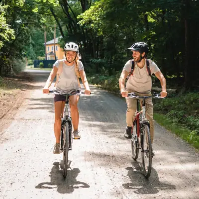 Ein Mann und eine Frau fahren auf einem Schotterweg Fahrrad.