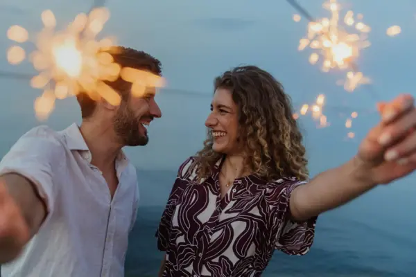 Ein Mann und eine Frau feiern Silvester in Bansin mit Wunderkerzen.