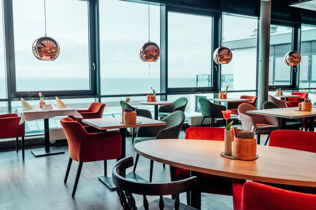 JEDERMANNS Restaurant Grömitz Ein Raum mit Tischen und Stühlen.