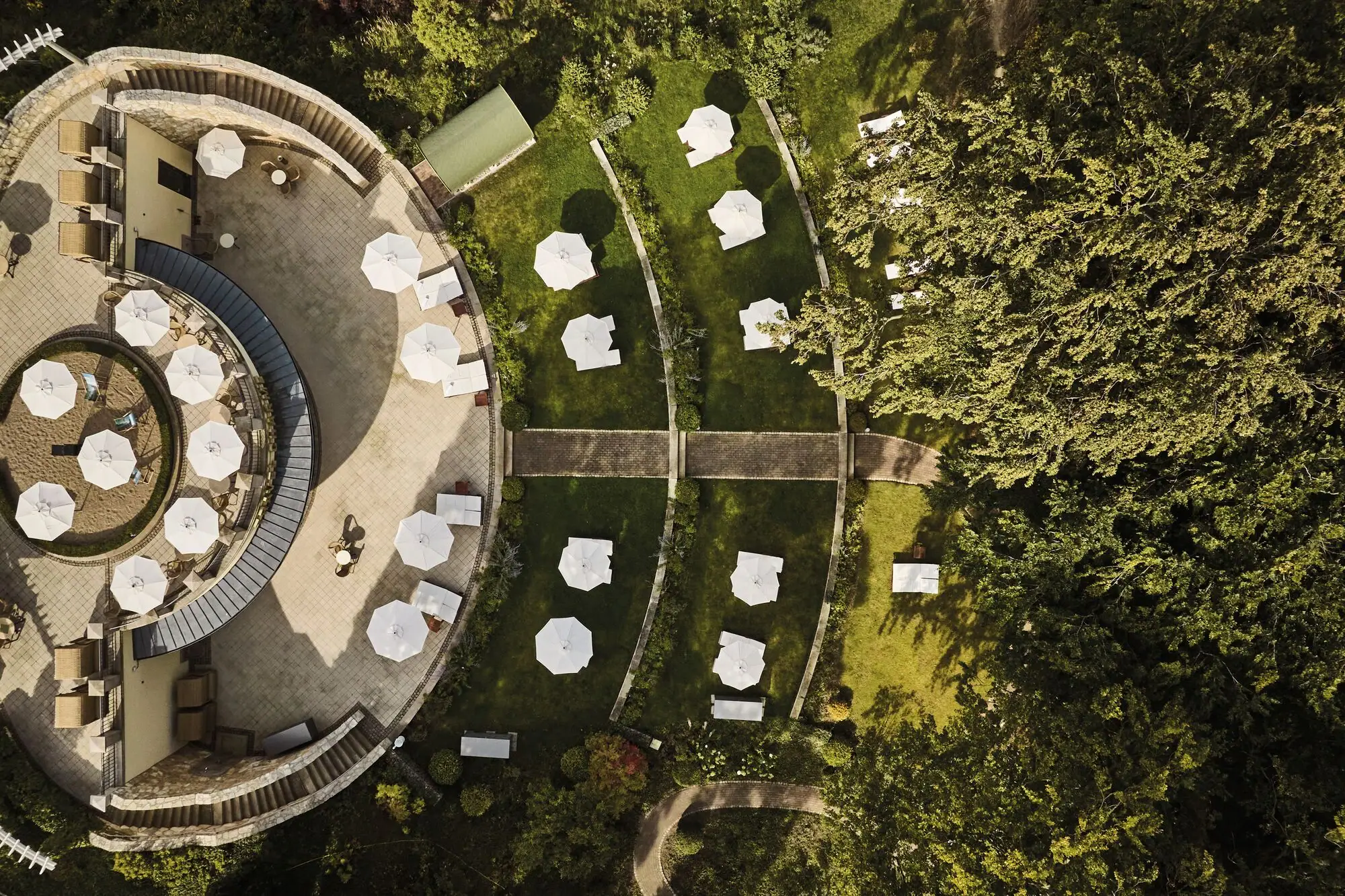 Luftaufnahme eines Gebäudes mit Sonnenschirmen und Grasflächen