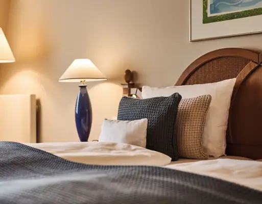 Ein Bett mit Kissen und einer Lampe.