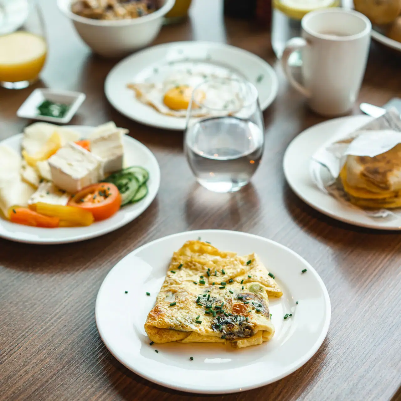 Frühstück Ein Tisch mit Tellern voller Speisen und Getränken.