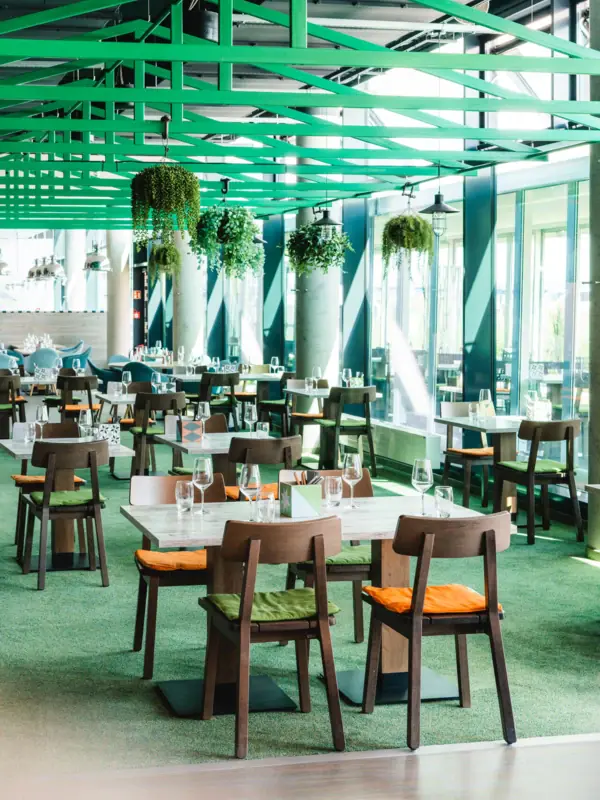 JEDERMANNS Restaurant Travemünde Ein Raum mit Tischen und Stühlen.