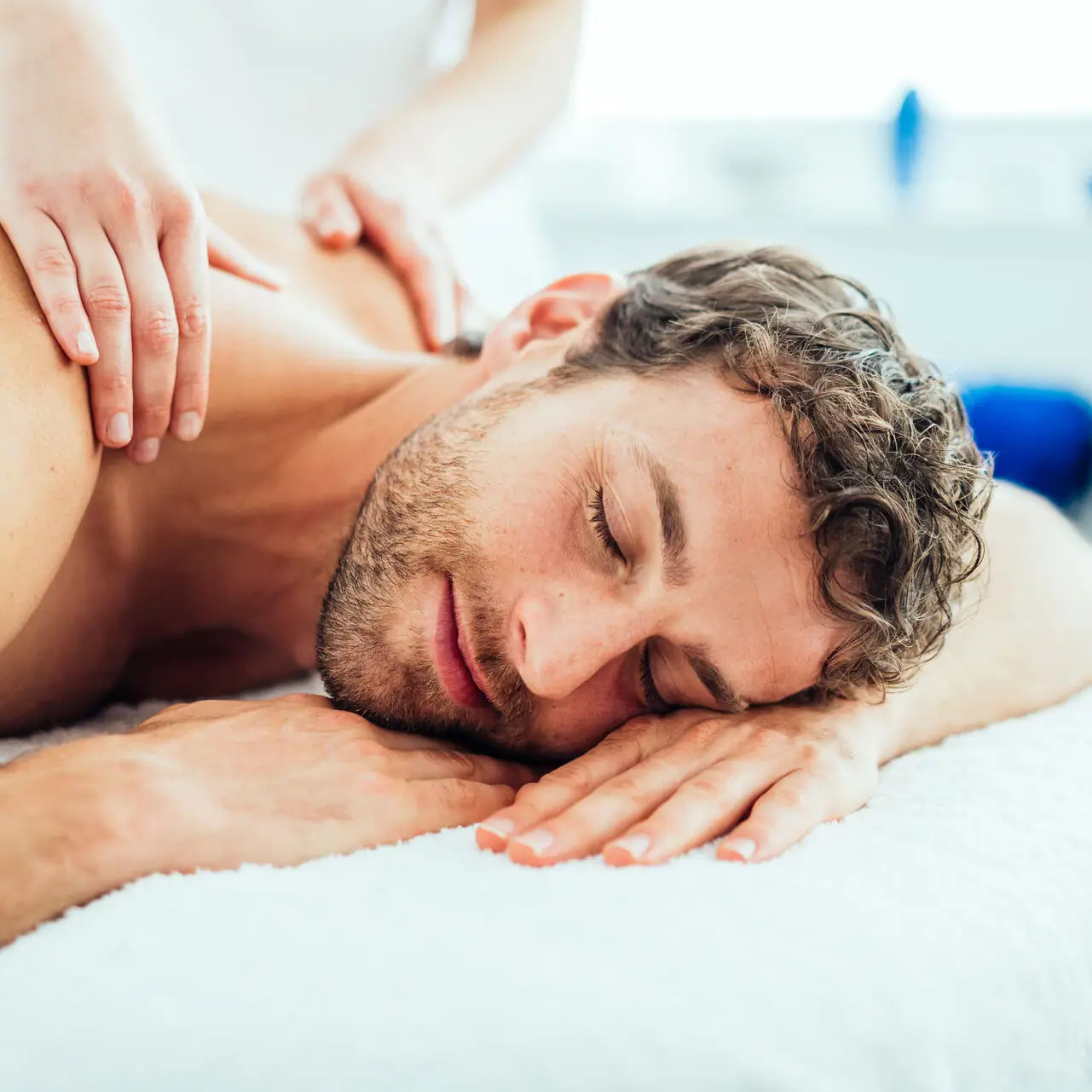 Ein Mann liegt auf einem Massagetisch.