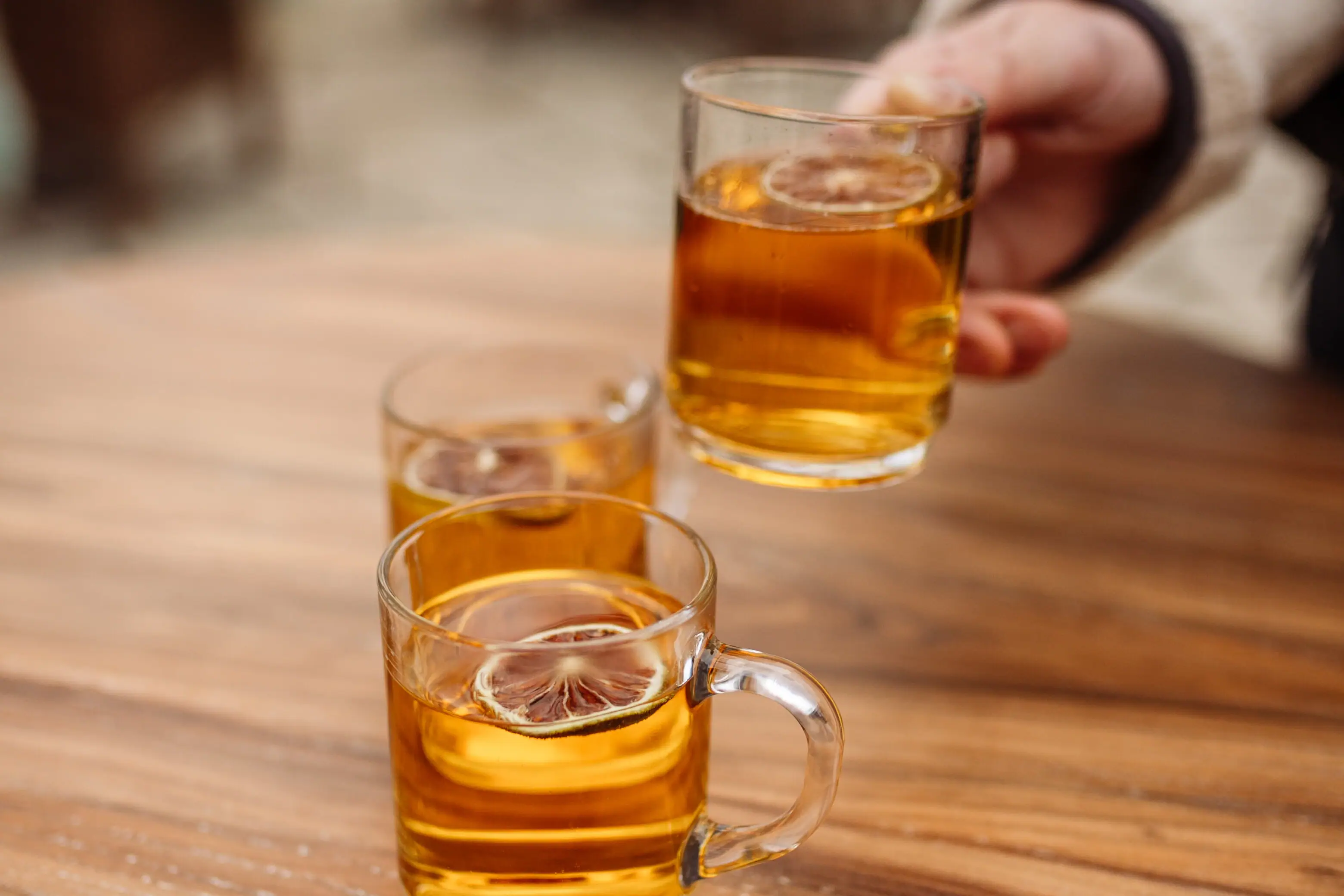 Eine Hand hält ein Glas mit einem alkoholischen Getränk.