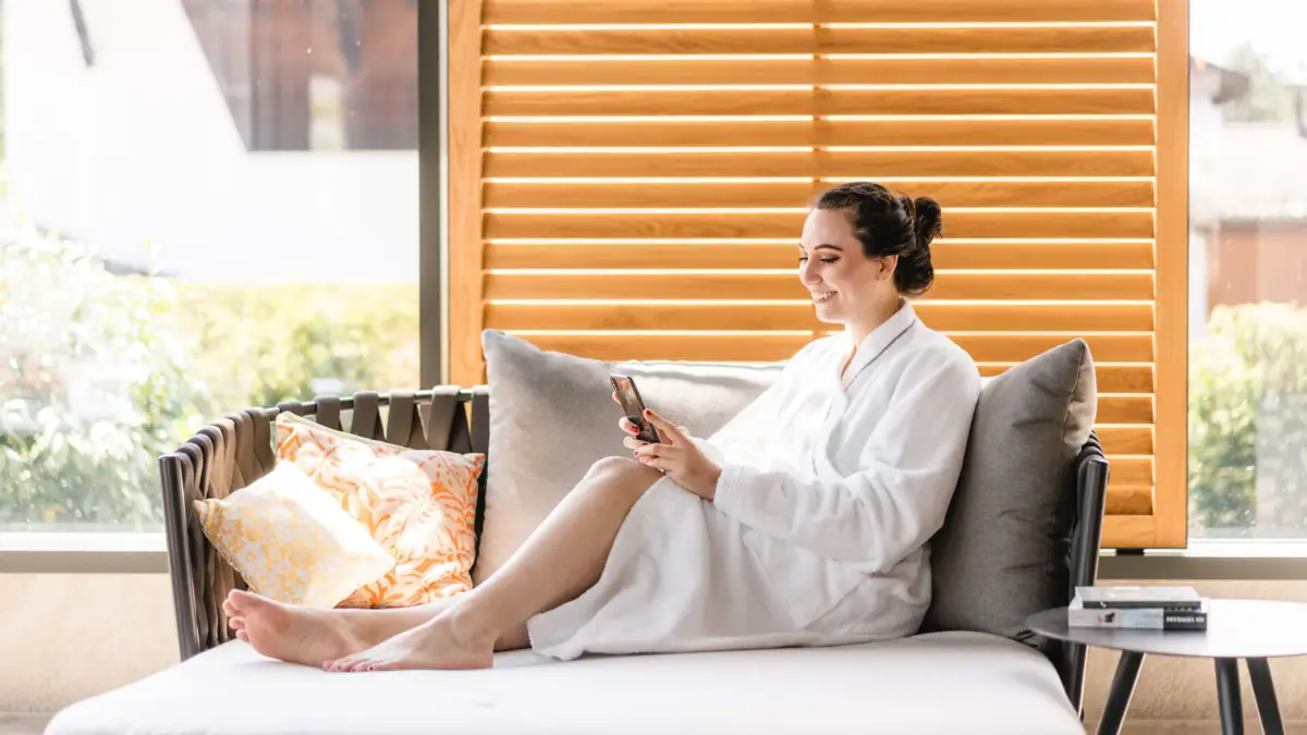 Eine Frau im Bademantel sitzt auf einem Sofa.