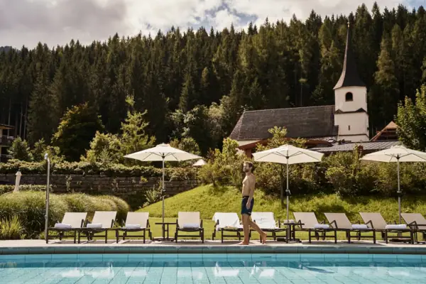 Ein Mann geht an einem Pool vorbei.