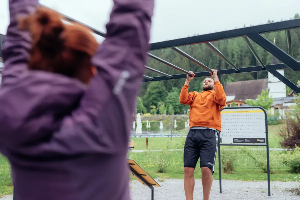 Outdoor-Fitness Ein Mann hält sich an Kletterstangen fest.
