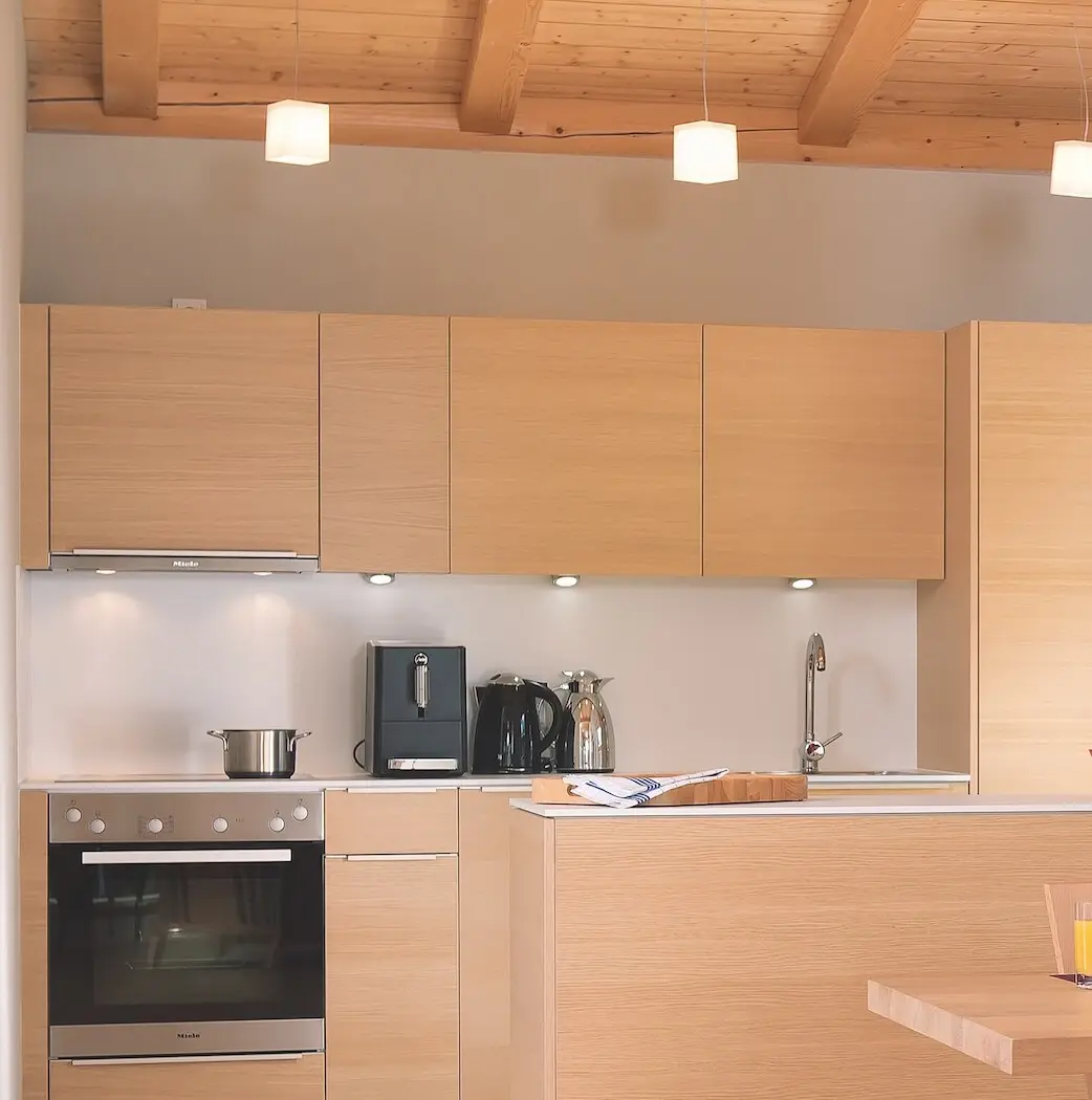 Kitchen with table and chairs, equipped with cupboards and modern kitchen appliances.