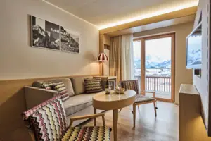 Ein Wohnzimmer mit Couch, Tisch und Stühlen.