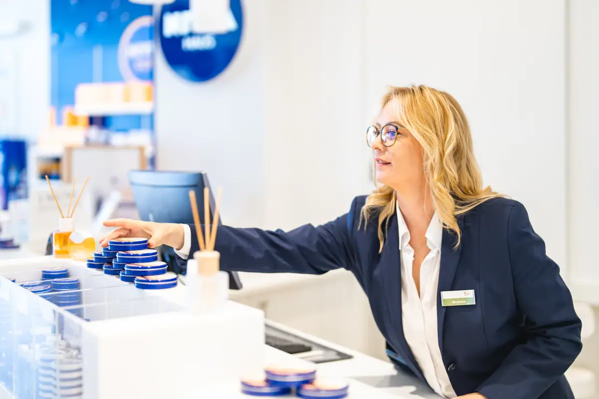 Nivea Shop Eine Frau im Anzug und Brille.