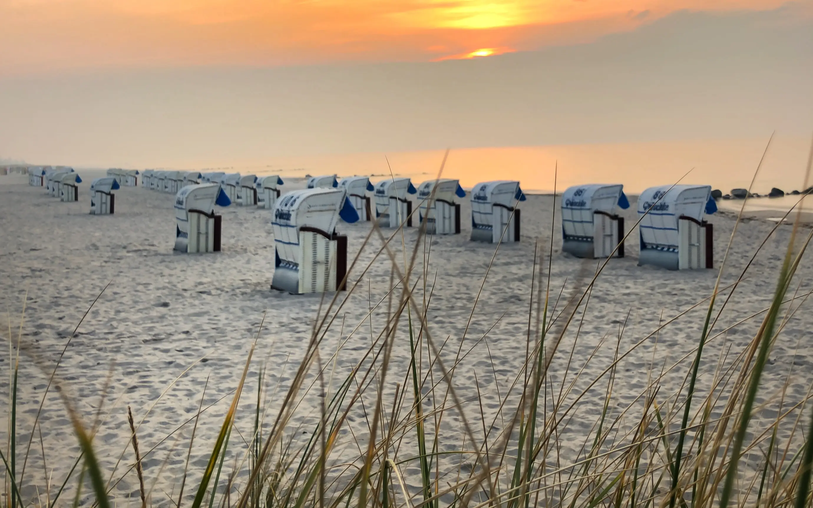 Tramonto sulla spiaggia con sedie a sdraio