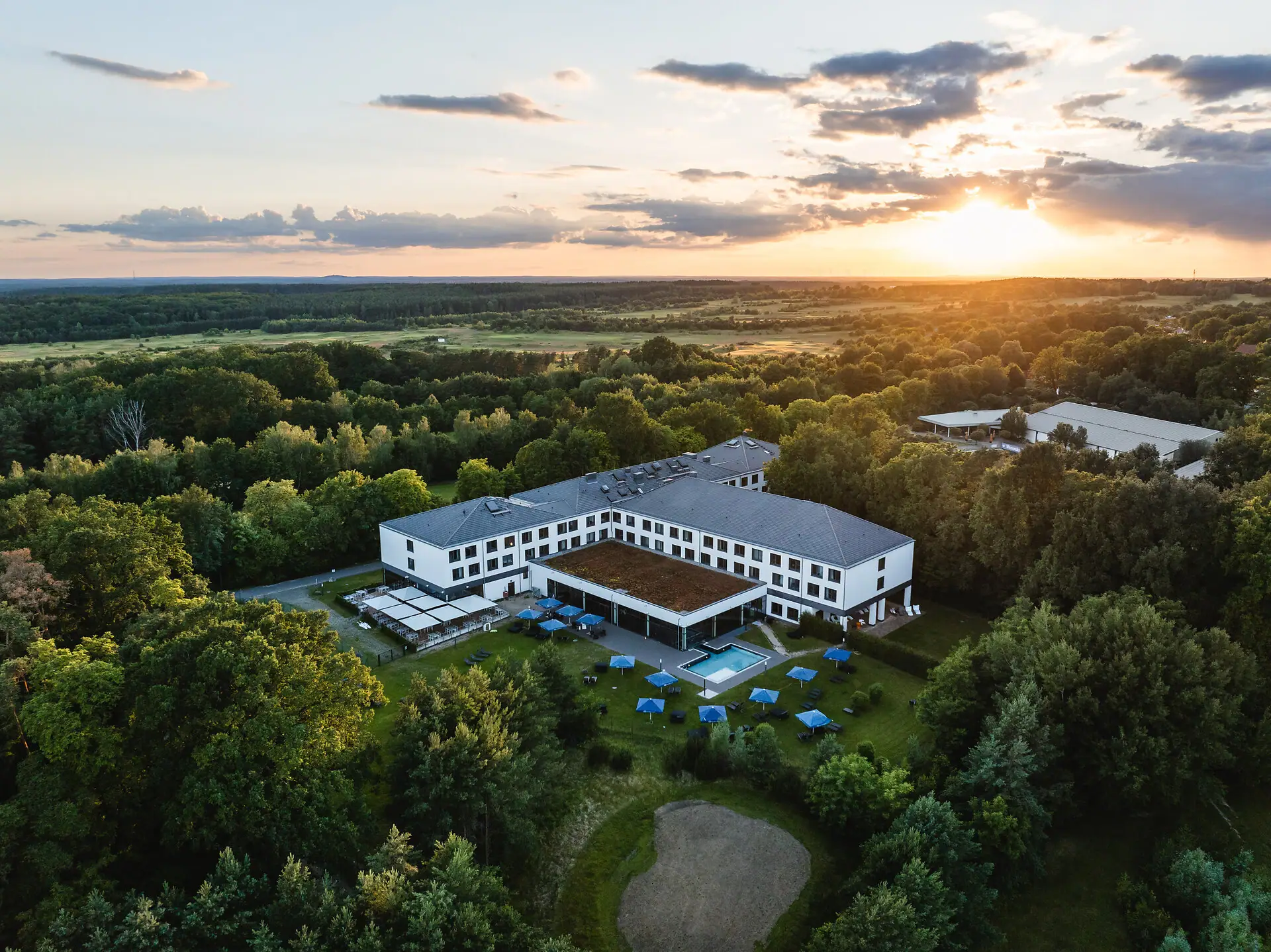 Ein Gebäude mit einem Pool, umgeben von Bäumen.