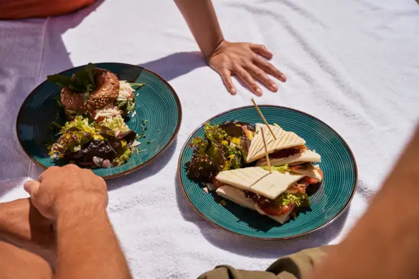 Ein Teller mit Sandwiches auf einer Decke.