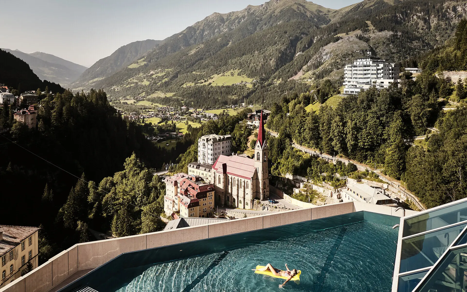 Person schwimmt in einem Pool mit einem großen Gebäude im Hintergrund.