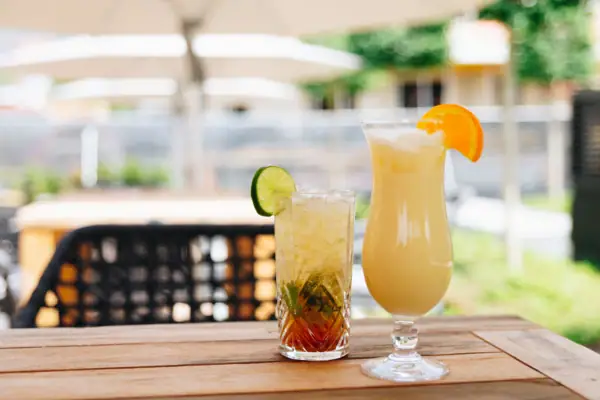 Cocktails Zwei Getränke auf einem Tisch, eines mit Cocktailgarnitur und Trinkhalm.