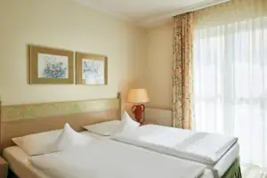 Ein Zimmer mit zwei Betten und einer Lampe.