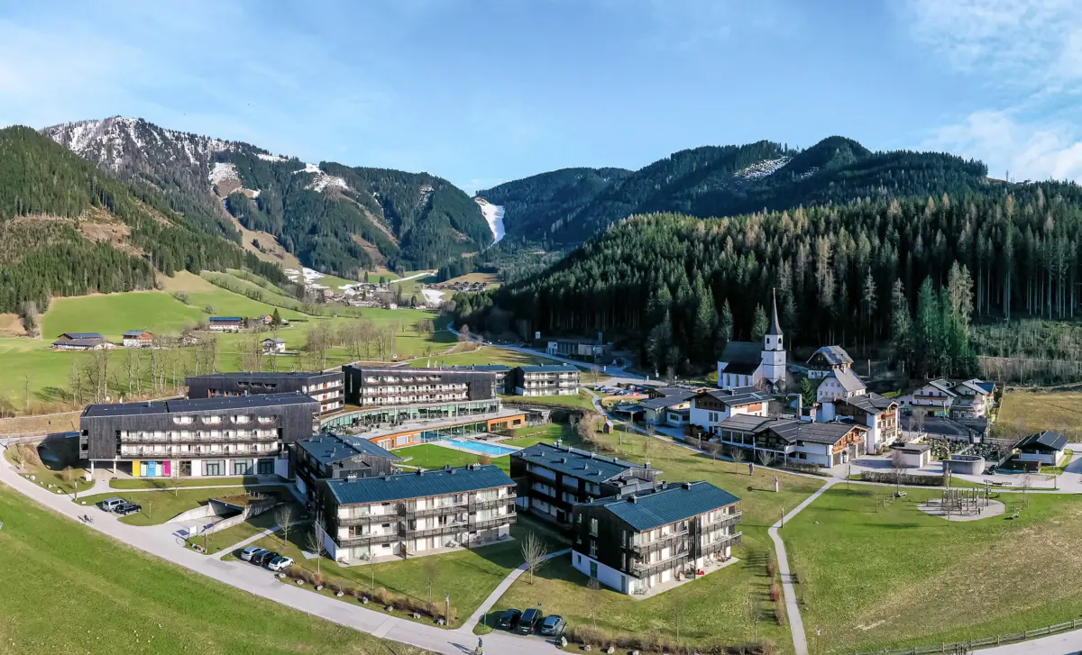 Das aja Bergresort Werfenweng von oben aus der Luft fotografiert mit Bergen im Hintergrund.