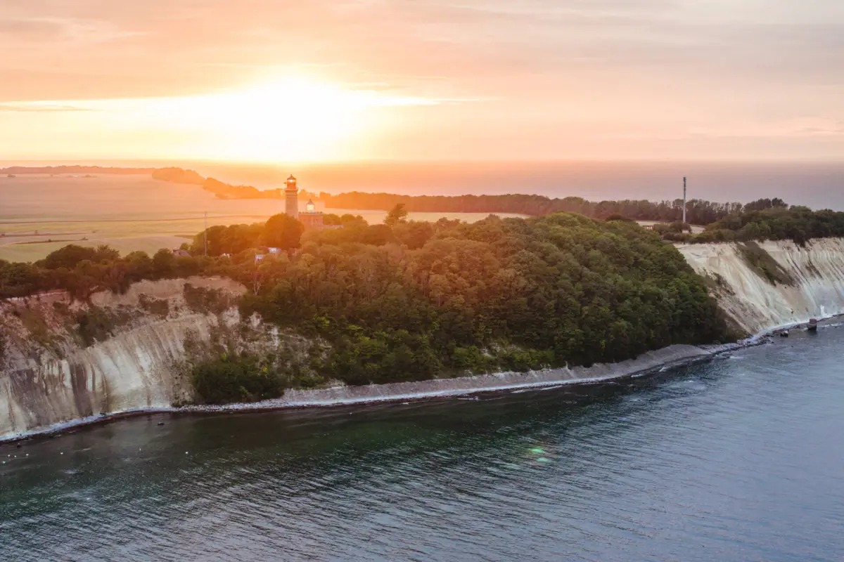 Ein Gewässer mit einem Leuchtturm auf einem Hügel.