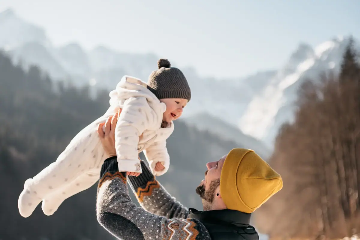 Ein Mann hält ein Baby in die Luft.