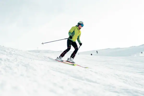 Eine Person fährt auf Skiern einen verschneiten Hang hinunter.