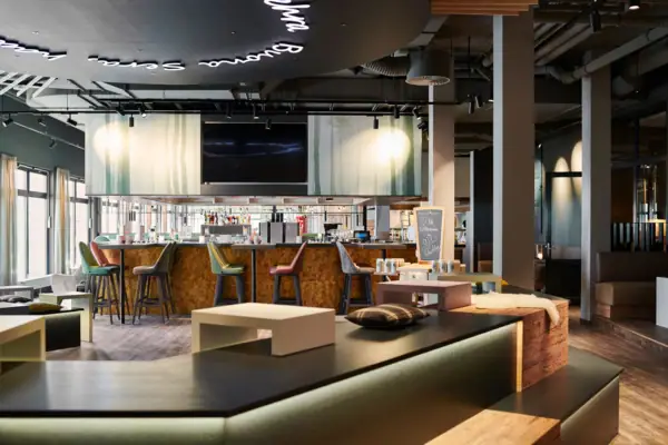 Eine Bar mit Fernseher und Barhockern.