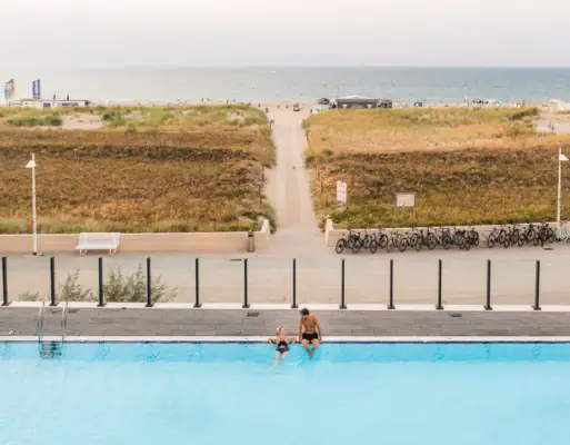 Außenpool im aja Warnemünde Ein Mann und eine Frau im Außenpool mit Blick auf die Ostsee.