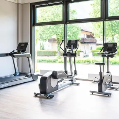 Fitness Ein Raum mit Fitnessgeräten und Fenstern.