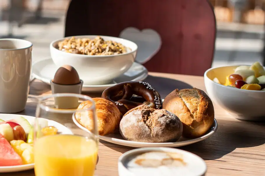 Frühstückstisch mit Brötchen Ein Tisch mit verschiedenen Speisen darauf.