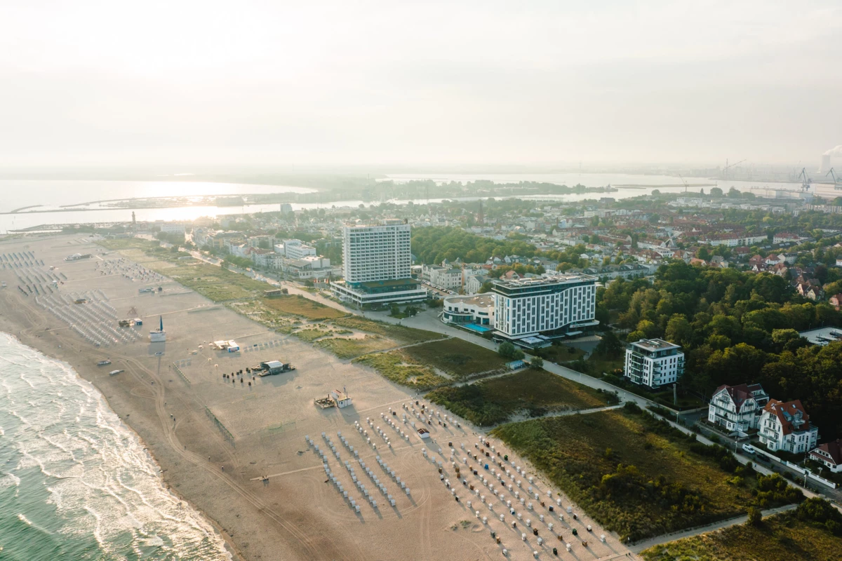 aja Warnemünde Strand mit Gebäuden und Bäumen aus der Vogelperspektive.