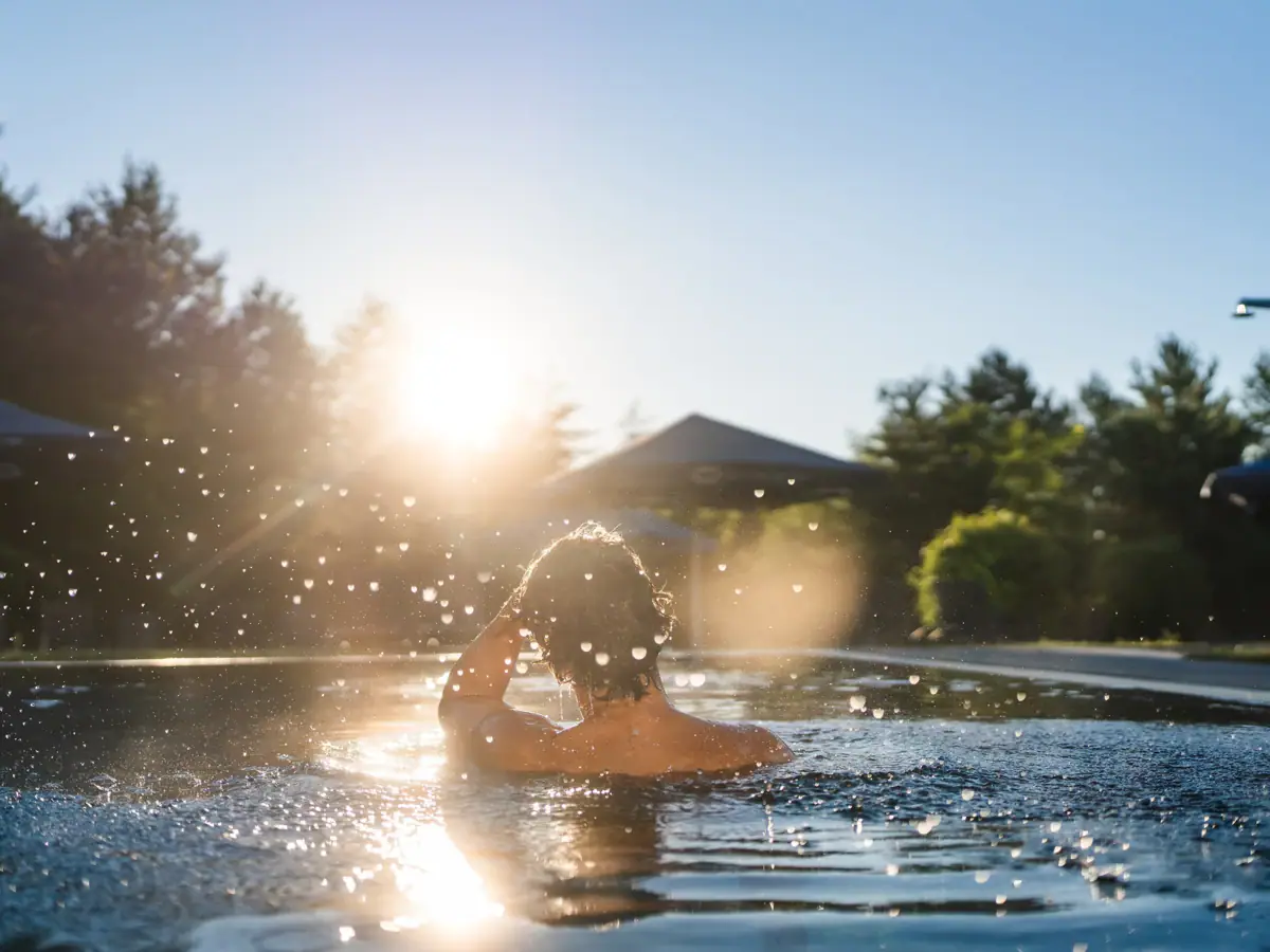 Eine Person schwimmt in einem Außenpool.