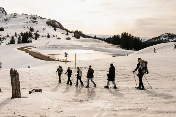 Eine Gruppe von Menschen geht auf Schnee.