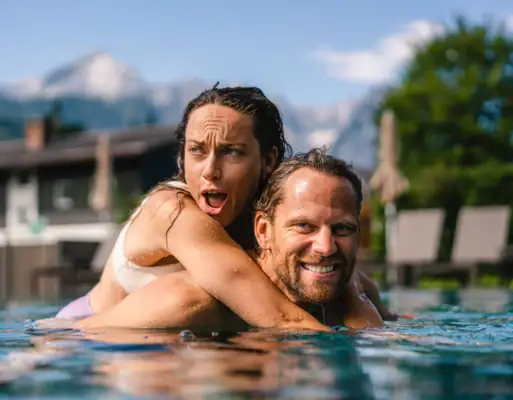 Ein Mann und eine Frau im Pool, lächelnd.