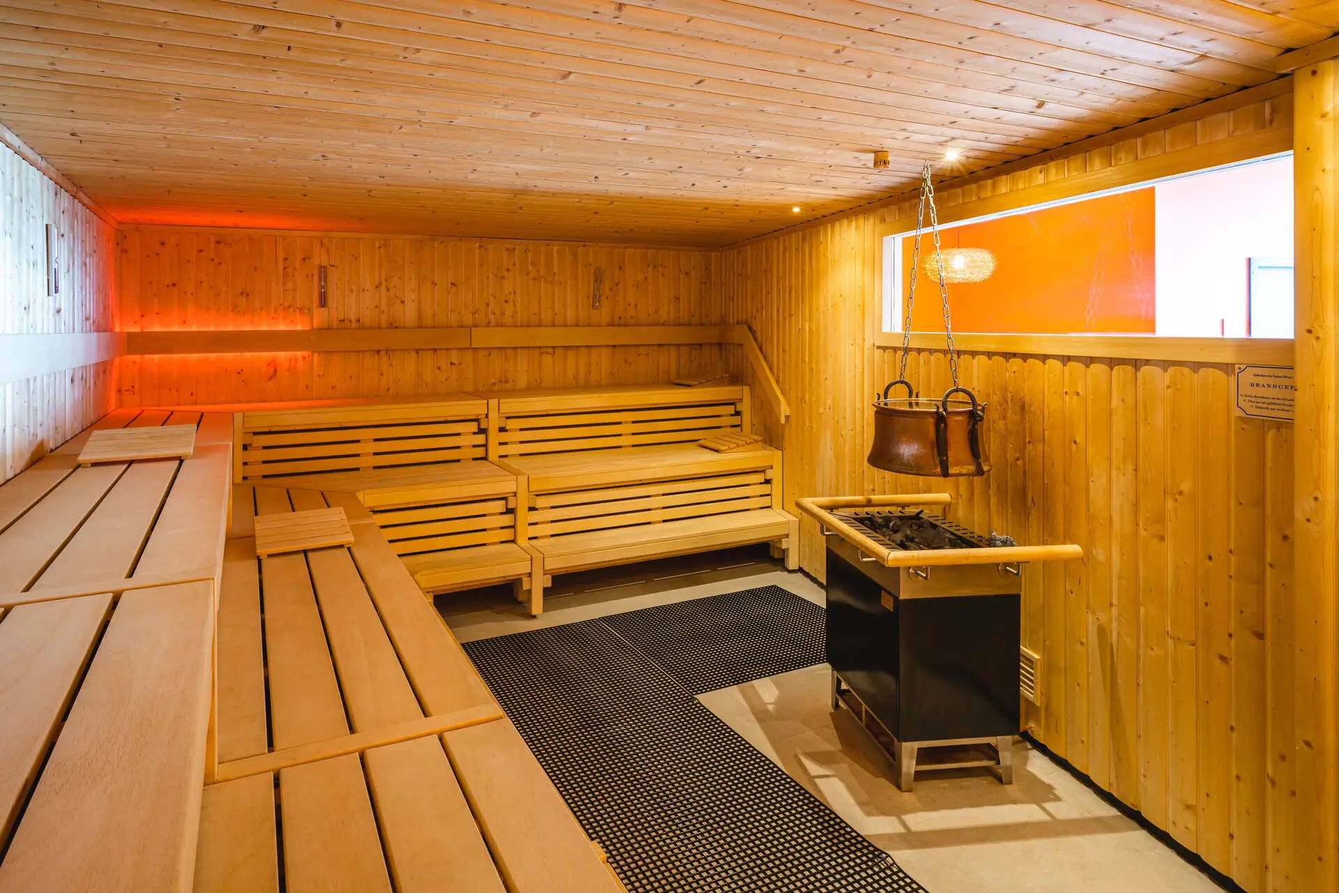 Eine Sauna mit Bänken und einem Ofen.