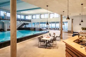 Ein Innenpool in einem Gebäude mit Decke und Möbeln.