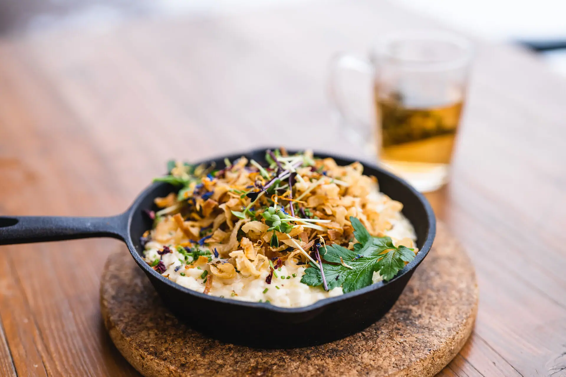 Käsespätzle Eine Pfanne mit Essen auf einem Tisch.